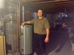 Weatherization client poses with his new hot water heater.